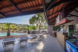 a patio with tables and chairs and a pool at Hotel Lumbarda in Lumbarda