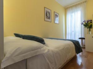 a bedroom with a bed with white sheets and blue pillows at Domus Penna in Rome