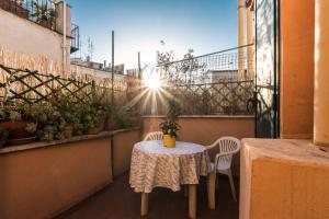 a table and chairs on a balcony with the sun shining at Domus Penna in Rome