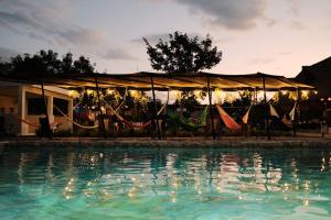 einen Pool mit Hängematten und ein Zelt mit einem Pool mit Wasser in der Unterkunft Hameki in Homún