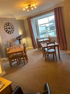 een eetkamer met tafels en stoelen en een raam bij Horncliffe room only accommodation in Seahouses