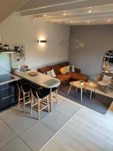 uma cozinha e sala de estar com uma mesa e um sofá em Gite de la tannerie 3 em Dinan