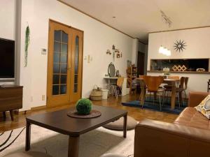 ein Wohnzimmer mit einem Sofa und einem Tisch in der Unterkunft MEILAN HOUSE - Vacation STAY 13804 in Osaka