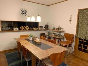 a dining room with a wooden table and chairs at MEILAN HOUSE - Vacation STAY 13804 in Osaka