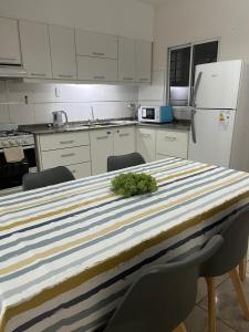 una cocina con una mesa con una planta verde. en Duplex Lisandro de la Torre en San Rafael