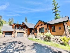 a large wooden house with a driveway at Highland Huckleberry Lodge in Whitefish