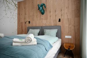 1 dormitorio con 1 cama con toallas en KUBÍNSKA HOĽA - Apartmány HILLSIDE point, en Dolný Kubín