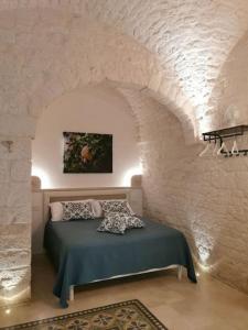 a bedroom with a bed in a stone wall at A casòdd' - Luxury Suite in Ceglie Messapica