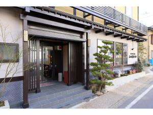 a front door of a building with a tree outside at Kusatsu Onsen 326 Yamanoyu Hotel - Vacation STAY 10465v in Kusatsu