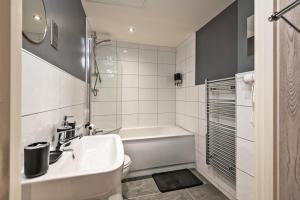 a bathroom with a sink and a toilet and a tub at NEW Luxury Smart Cinema Stylish Apartment in Bradford