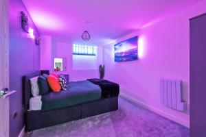 a pink bedroom with a bed with a purple ceiling at NEW Luxury Smart Cinema Stylish Apartment in Bradford
