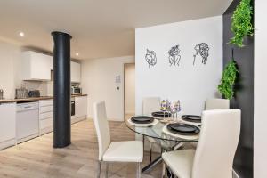 a kitchen and dining room with a table and chairs at NEW Luxury Smart Cinema Stylish Apartment in Bradford