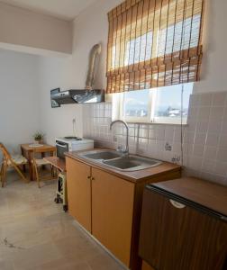 een keuken met een wastafel, een fornuis en een raam bij CityCenter Apartment in Mesolongion