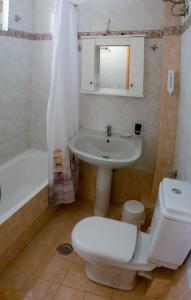 La salle de bains est pourvue de toilettes, d'un lavabo et d'une baignoire. dans l'établissement CityCenter Apartment, à Mesolongion
