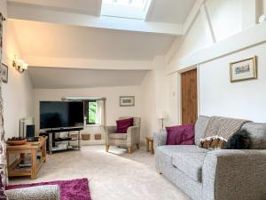 a living room with a couch and a tv at Hilltop Barn in Starbotton