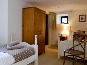 a bedroom with a bed and a dresser and a chair at Hilltop Barn in Starbotton