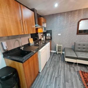 a kitchen with a sink and a couch in a room at Town Centre Maisonette in Ulverston