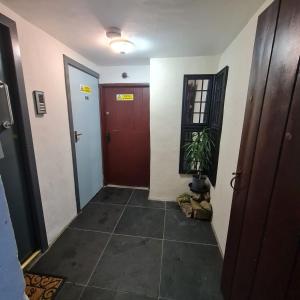 a hallway with a red door and a plant at Town Centre Maisonette in Ulverston