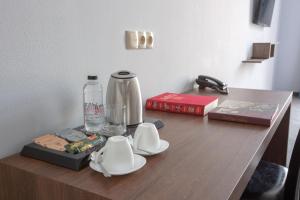 a table with a coffee maker and a phone on it at Alma Boutique Hotel in Tbilisi City