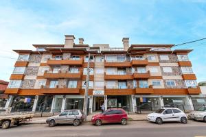 un gran edificio con coches estacionados frente a él en Campos de Canela 402 - Stay House Temporada, en Canela