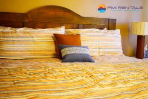 een bed met gestreepte lakens en kussens erop bij Marina Pinacate B-319 in Puerto Peñasco