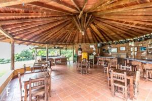 ein Restaurant mit Holztischen und -stühlen und einer Bar in der Unterkunft Finca Quinta San Antonio, Girardota, Antioquia in Girardota