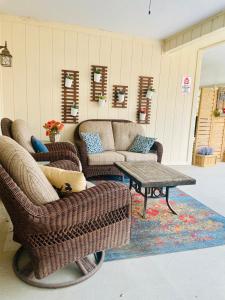 a living room with two wicker chairs and a table at Lamb's Rest Inn in New Braunfels