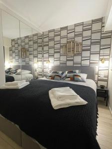 Un dormitorio con una gran cama negra con toallas. en Sublime Coeur Deauville en Deauville