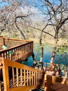 een houten terras met uitzicht op een waterlichaam bij Lamb's Rest Inn in New Braunfels