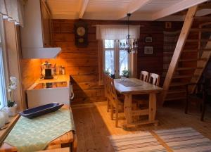 eine Küche mit einem Tisch in einem Holzhaus in der Unterkunft 100 Years Old Norwegian Log House in Tromsø in Tromsø