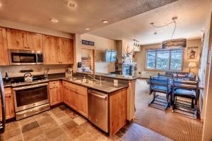 a kitchen with wooden cabinets and a kitchen with a table at Morning Eagle 411 in Whitefish