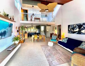 ein Wohnzimmer mit einem blauen Sofa und einem Esszimmer in der Unterkunft Delícia de casa em Barra do Una a 5 min de Juquehy! in São Sebastião