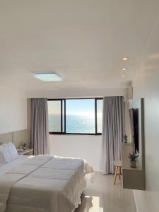 a bedroom with a large bed and a large window at Praia da Costa, SUNRISE STAY in Vila Velha
