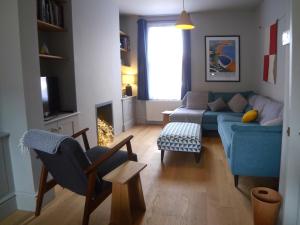 a living room with a blue couch and a chair at Kittiwake Cottage in Scarborough