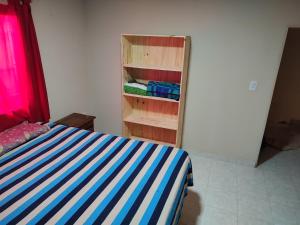 1 dormitorio con cama y estante para libros en Casas Arnau en Termas de Río Hondo