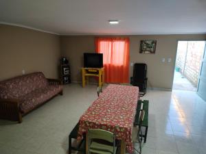 sala de estar con mesa y sofá en Casas Arnau en Termas de Río Hondo