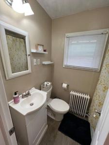 baño con lavabo y aseo y ventana en The Purple Door apt in the heart of Radford city, en Radford