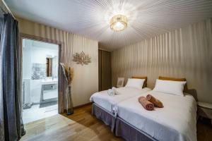 a bedroom with two beds and a chandelier at La cour du grand marché in Tours