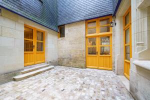 a building with two wooden doors and a tile floor at La cour du grand marché in Tours