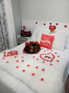 una cama con un montón de corazones rojos en ella en Suíte da Cris em Gramado, en Gramado