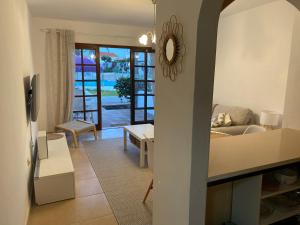 a living room with a view of a room with a couch at Estrella Del Mar 8. 1 Bedroom Villa with Pool and Gardens 300 metres from the beach in Corralejo