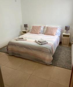 a bedroom with a large bed with two night stands at Estrella Del Mar 8. 1 Bedroom Villa with Pool and Gardens 300 metres from the beach in Corralejo