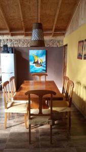 a dining room table and chairs with a painting on the wall at Arriendo Casa Pichidangui in Los Vilos