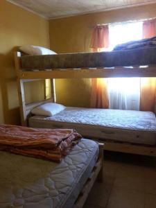 a room with two bunk beds and a window at Arriendo Casa Pichidangui in Los Vilos