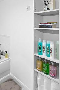a bathroom closet with bottles of detergent and a sink at Location, Location, Location with King Size Bed in Kent
