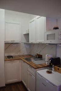 eine Küche mit weißen Schränken und einem Waschbecken in der Unterkunft Green Life Bansko Apartments in Bansko