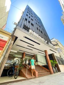 Un uomo in piedi di fronte a un edificio di Gran Hotel Buenos Aires a Buenos Aires