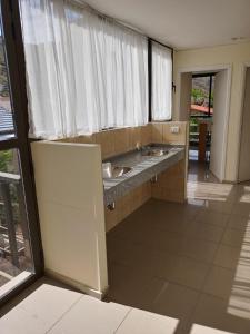 uma casa de banho com 2 lavatórios e uma grande janela em Chalet en Valle Grande - En Solar del Valle Country Club em Valle Grande