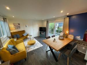a living room with a yellow couch and a table at Beachhouses Texel in De Koog