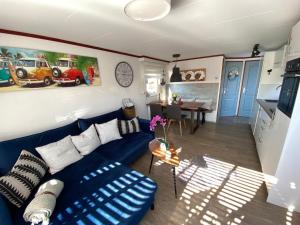 a living room with a blue couch and a table at Beachhouses Texel in De Koog